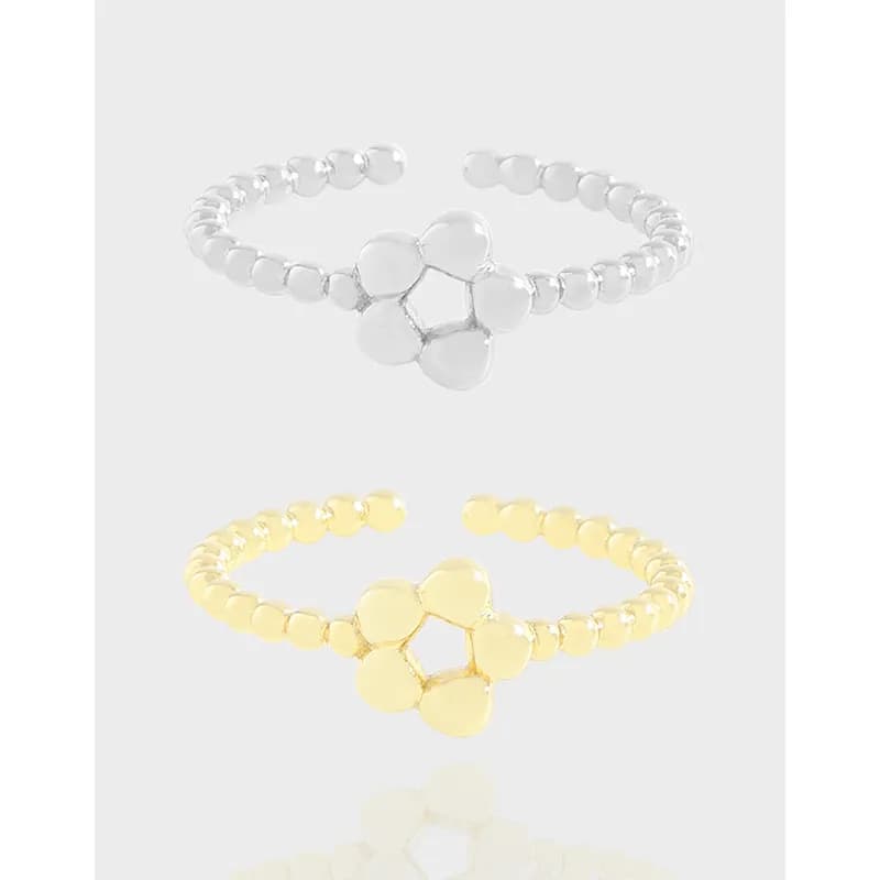 Polished beaded-band ring featuring a central five-petal flower motif in silver and gold-tone versions.