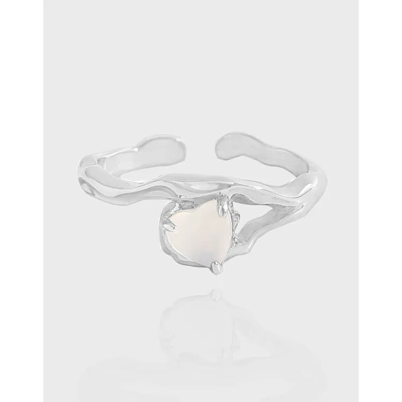 Polished sterling silver ring with a wavy band and a pale iridescent moonstone centerpiece