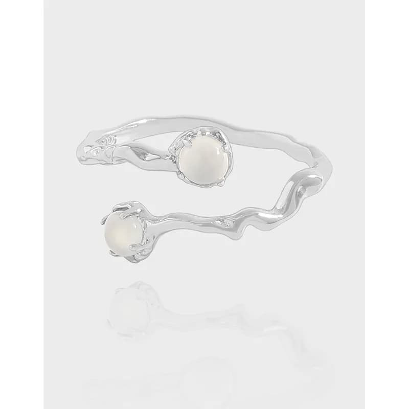 Polished sterling silver wavy ring with two pearl beads at opposite ends.
