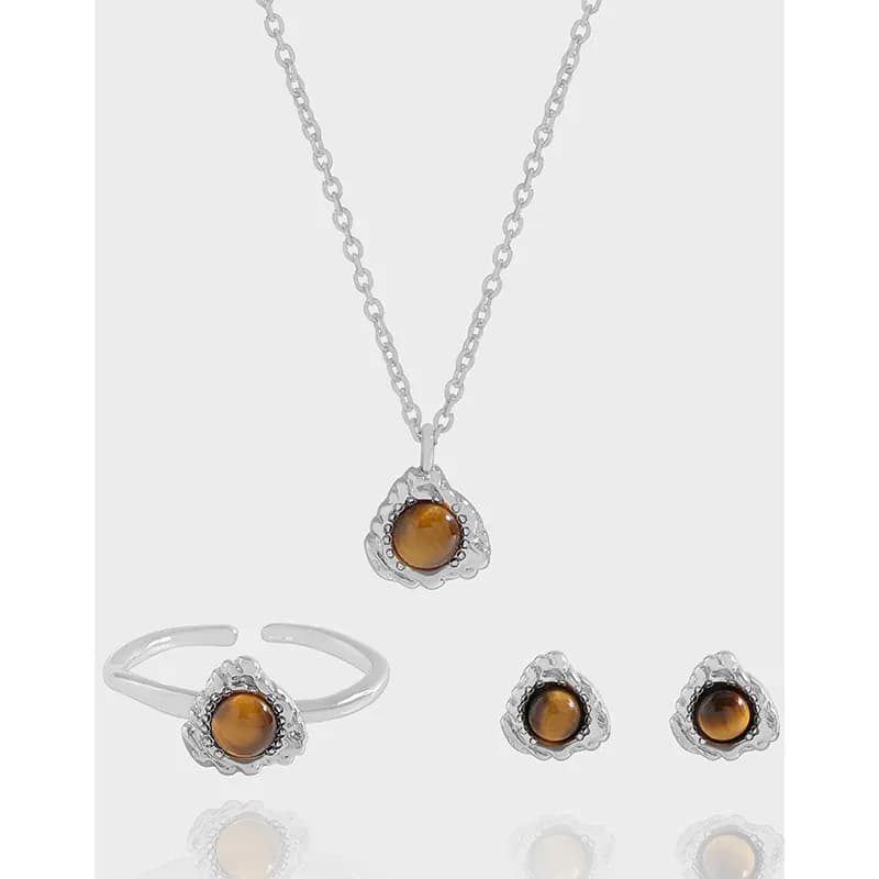 Silver tiger’s eye stud earrings with a matching pendant shown in a minimalist jewelry set.