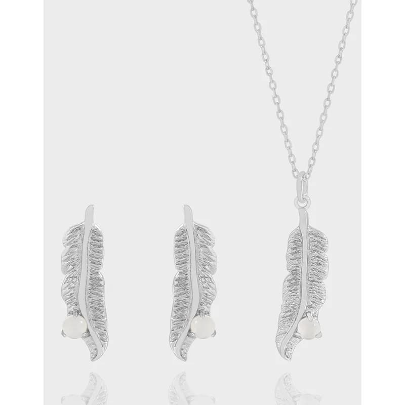Polished silver feather drop earrings with a matching feather pendant on a chain.