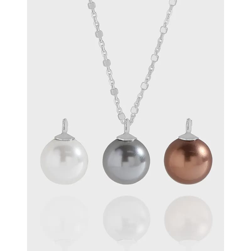 Three pearl pendants in white, gray, and copper hang from a polished sterling silver square-link chain.