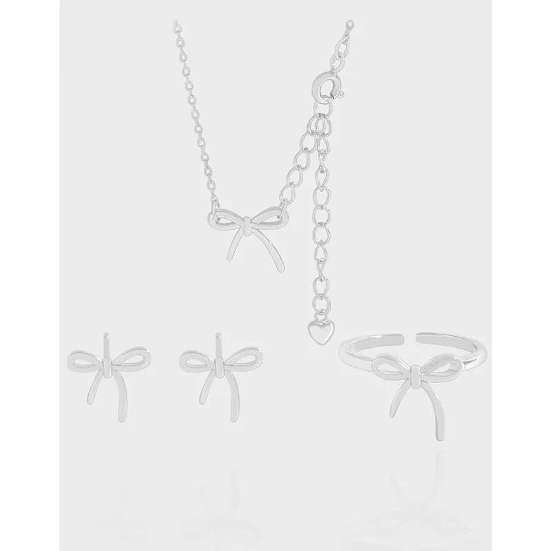A pair of polished sterling silver bow-shaped earrings from a set with a matching bow necklace and jewelry pieces.