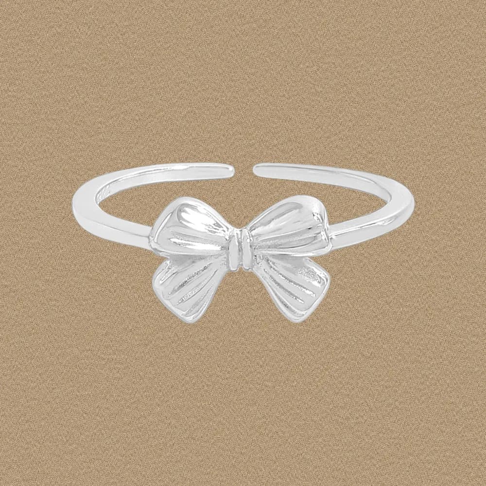 Close-up of a polished sterling silver bow ring with an open band