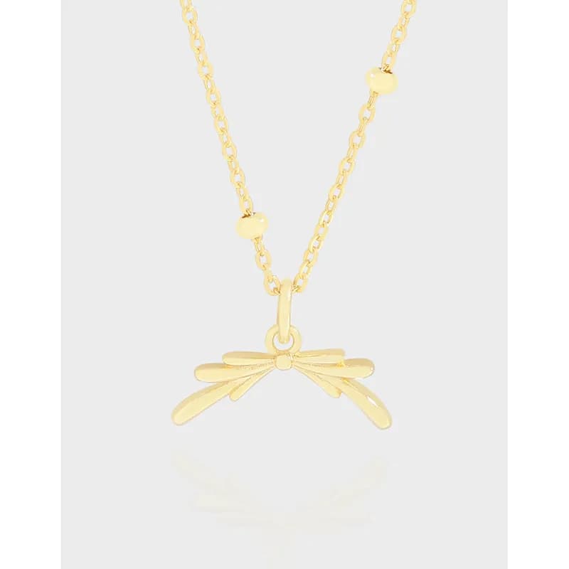 Close-up of a polished silver bow pendant hanging from a delicate chain.