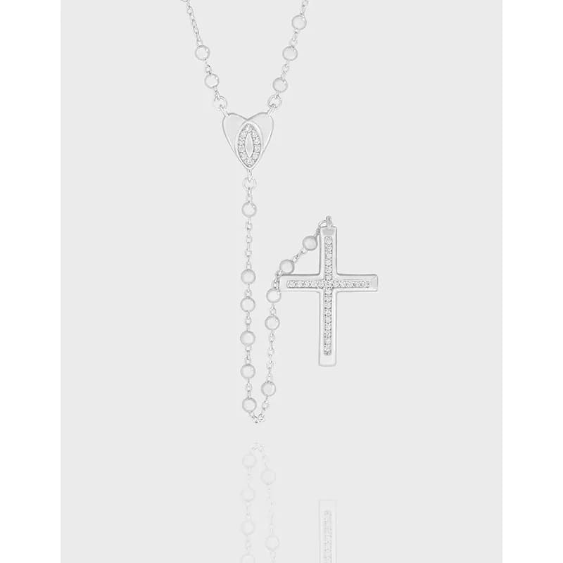 Polished sterling silver necklace with a heart pendant and a pavé cross pendant hanging on a delicate chain.