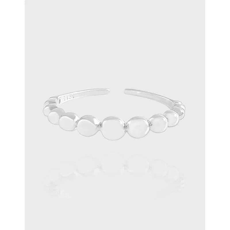 Polished sterling silver open-band ring with a row of circular discs along the front
