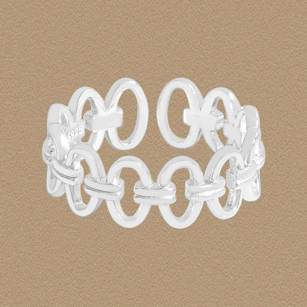 Polished sterling silver circle-link ring with interlocking loops on a warm beige background.
