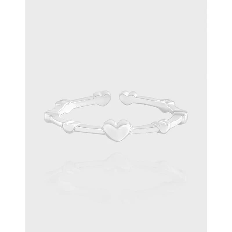 Polished sterling silver ring with heart-shaped links arranged along a thin open band