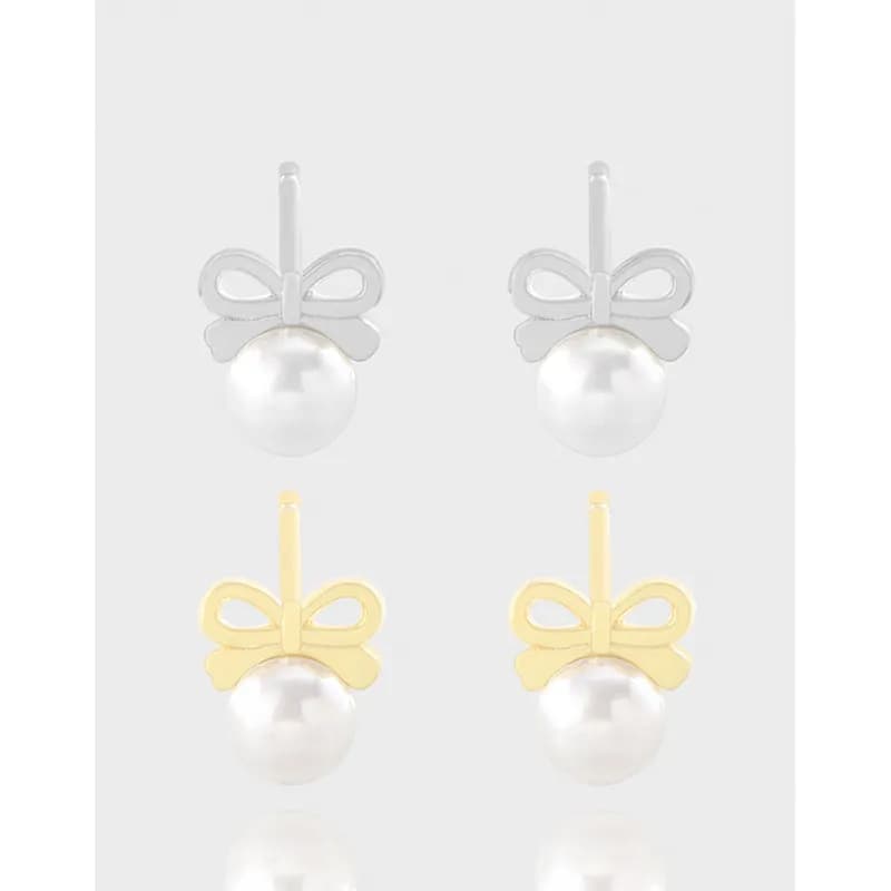 Delicate bow pearl drop earrings in silver and gold finishes with a round white pearl
