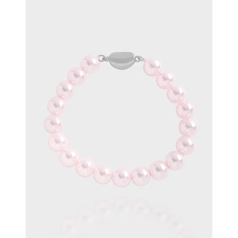 Pink pearl bead bracelet with a silver clasp on a light background