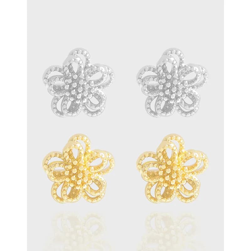 Polished sterling silver flower filigree earrings in silver and gold tones displayed as a pair.