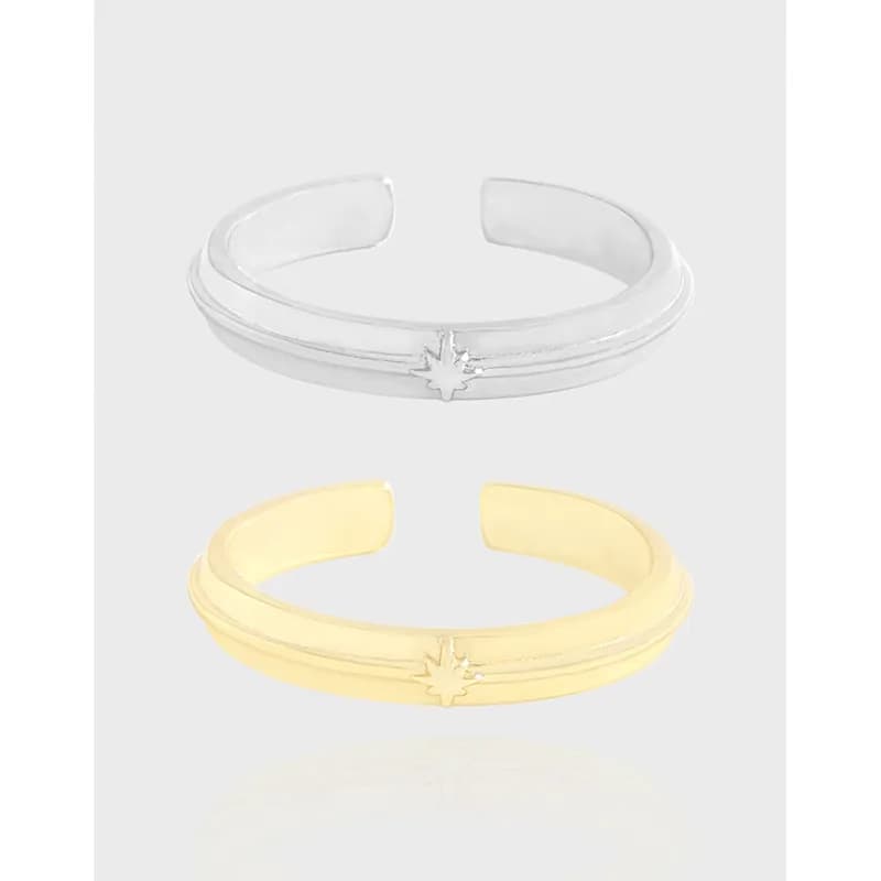 Open double-band ring with a small starburst detail in silver and gold finishes