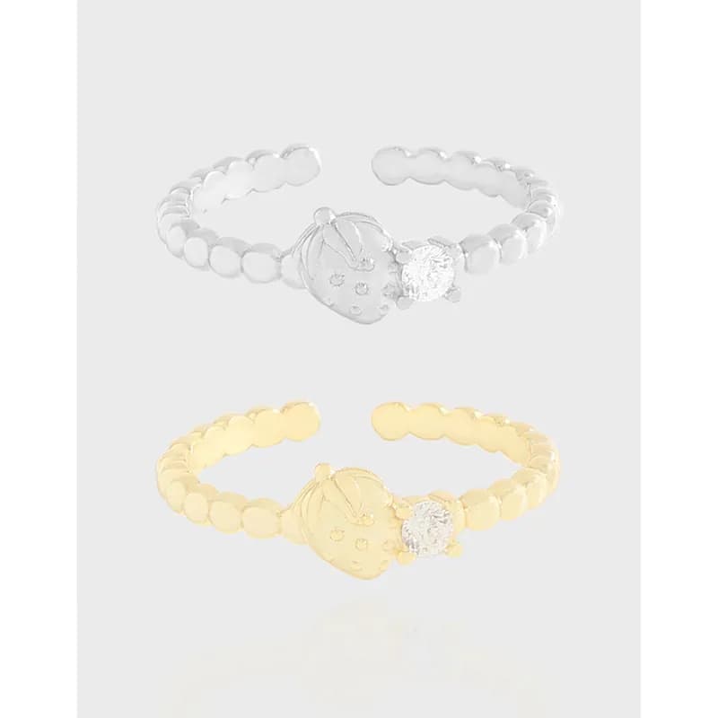 Polished sterling silver beaded ring with a circular cratered disk and crystal accent on a minimal open band.