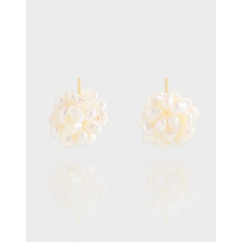 Polished sterling silver pearl cluster earrings shown as round studs with a dense arragement of white baroque pearls.