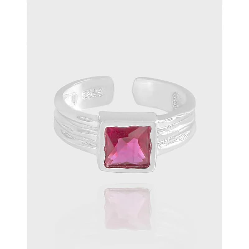 Silver triple-band ring with a square pink gemstone bezel set in the center.