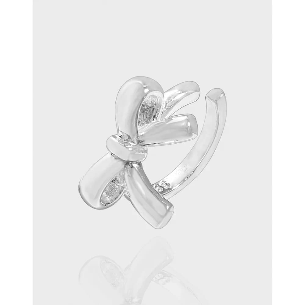 Polished sterling silver bow-shaped earring with curved ribbon design against a light background.