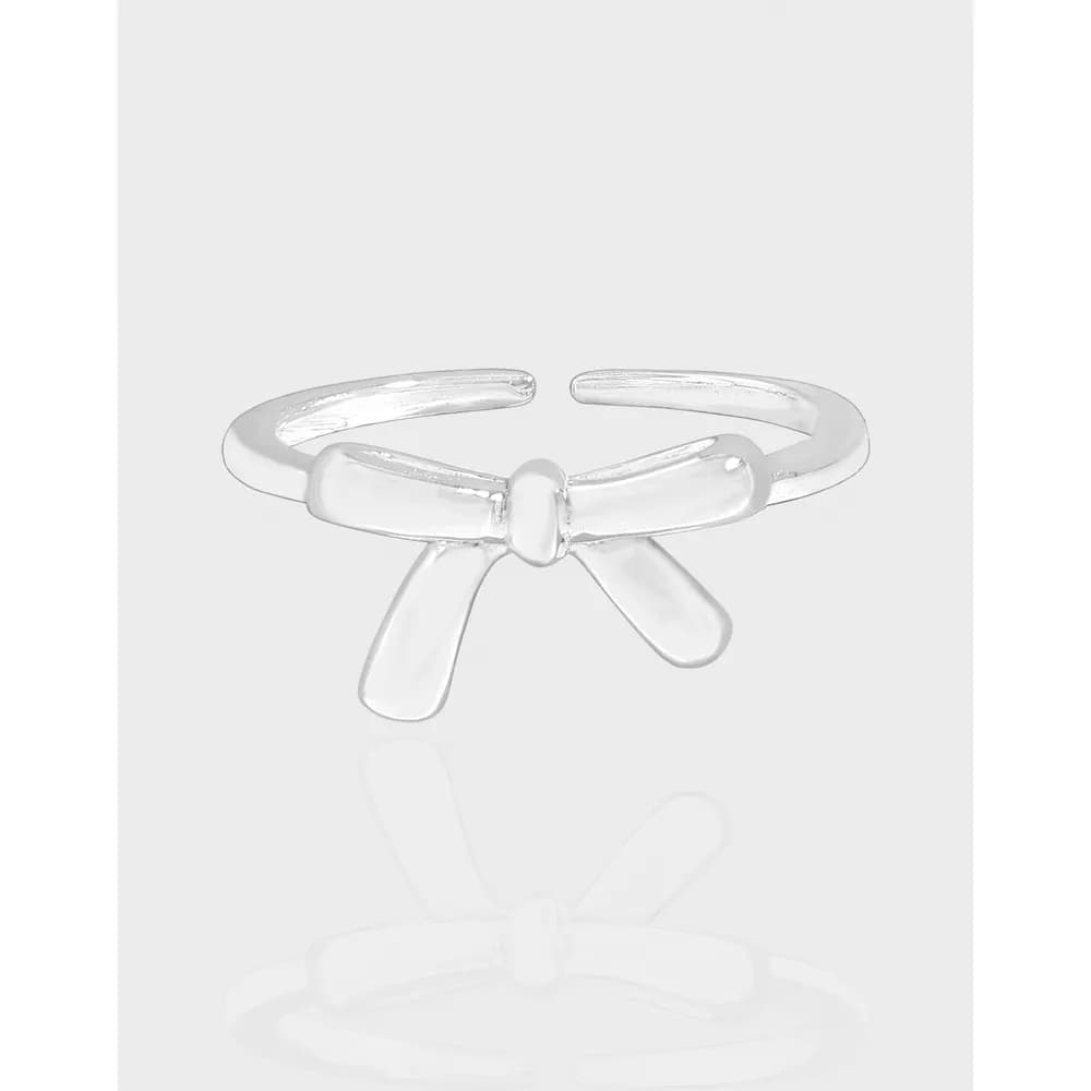 Polished sterling silver Bow Ribbon Ring with a central knot and two ribbon-like tails on an open band.