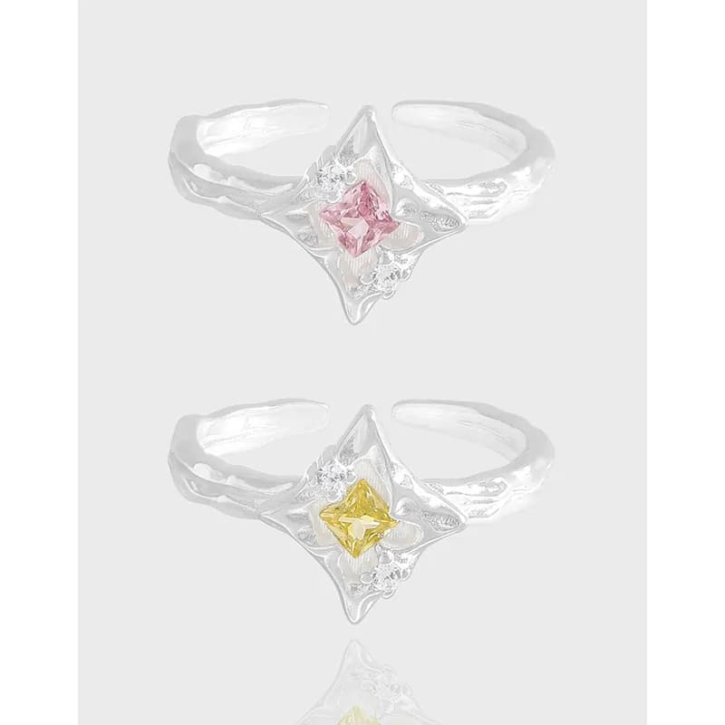 Two sterling silver rings with a starburst openwork motif and square enamel stones in pink and yellow