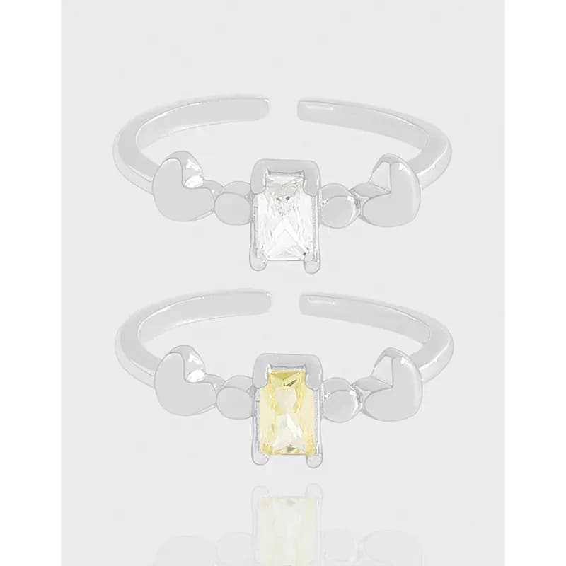 Polished sterling silver ring with an emerald-cut centerpiece and heart accents on each side.