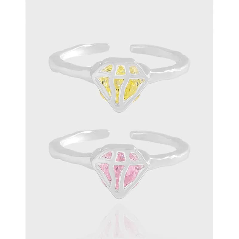 Two polished sterling silver rings with a diamond-lattice centerpiece and colored enamel windows in yellow and pink.