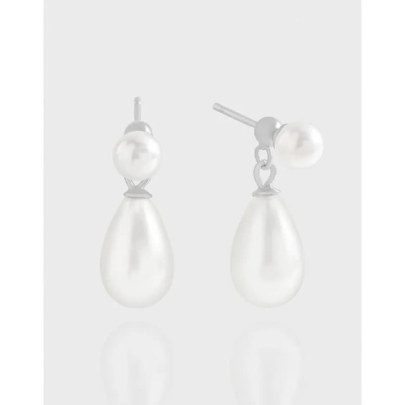 Sterling silver pearl drop earrings with a small stud pearl and a larger teardrop pearl hanging below.