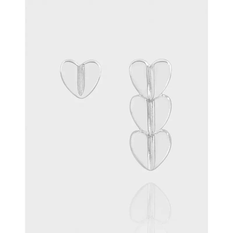 Polished sterling silver heart stud and three-heart drop earring shown against a light background.