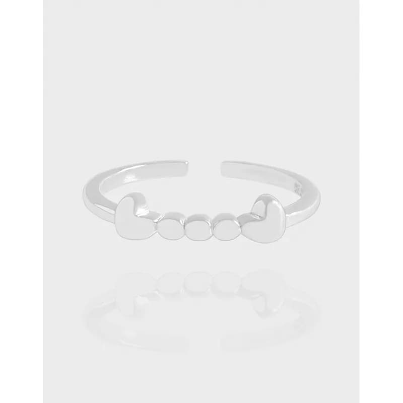 Polished sterling silver open ring with heart-shaped ends and three central beads.
