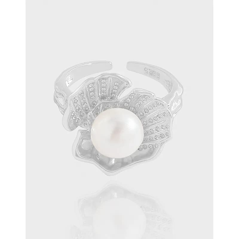 Sterling silver ring with a large white pearl centerpiece surrounded by petal-shaped, pavé-detailed petals.