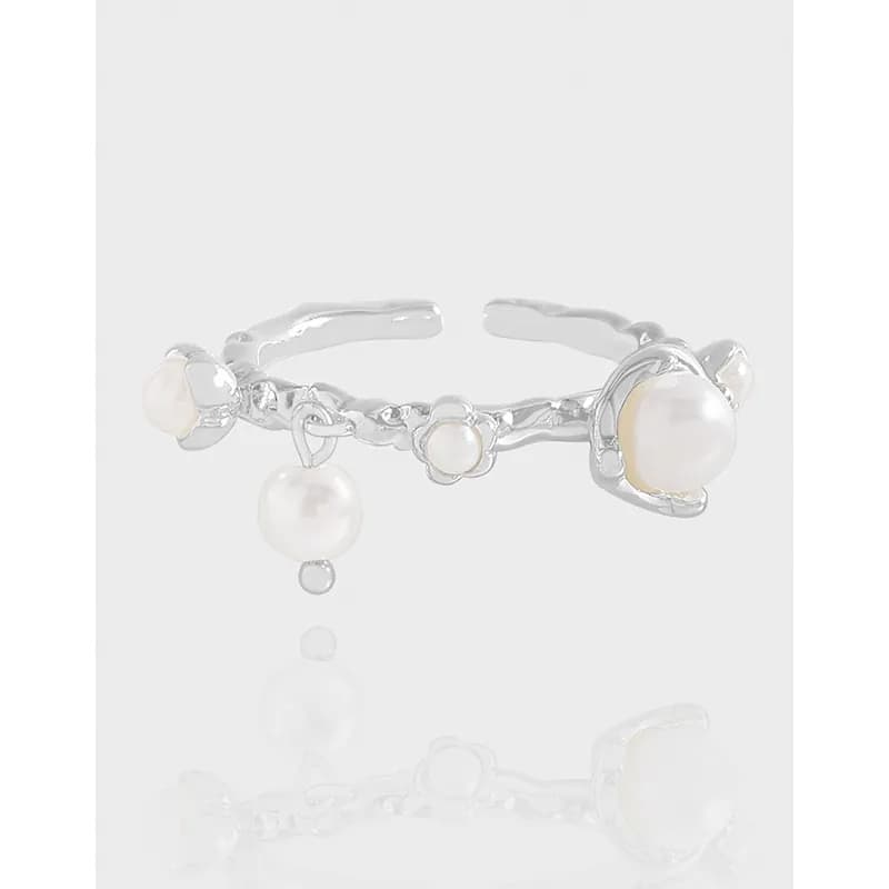Open sculpted sterling silver ring with scattered pearls and a dangling pearl charm.