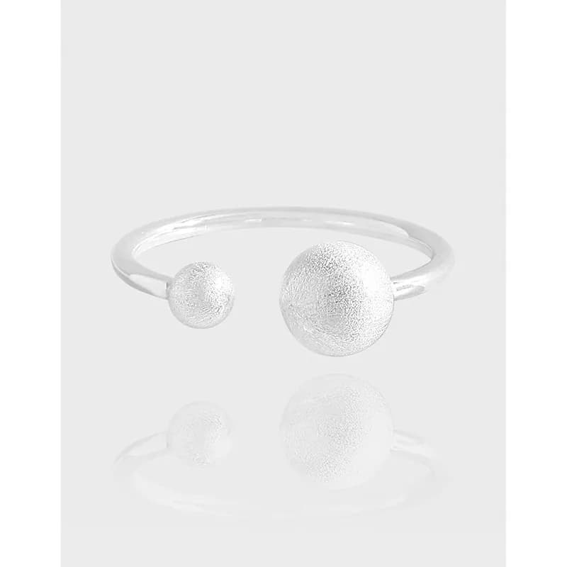 Open-end sterling silver ring with small and large textured spheres on a polished band.