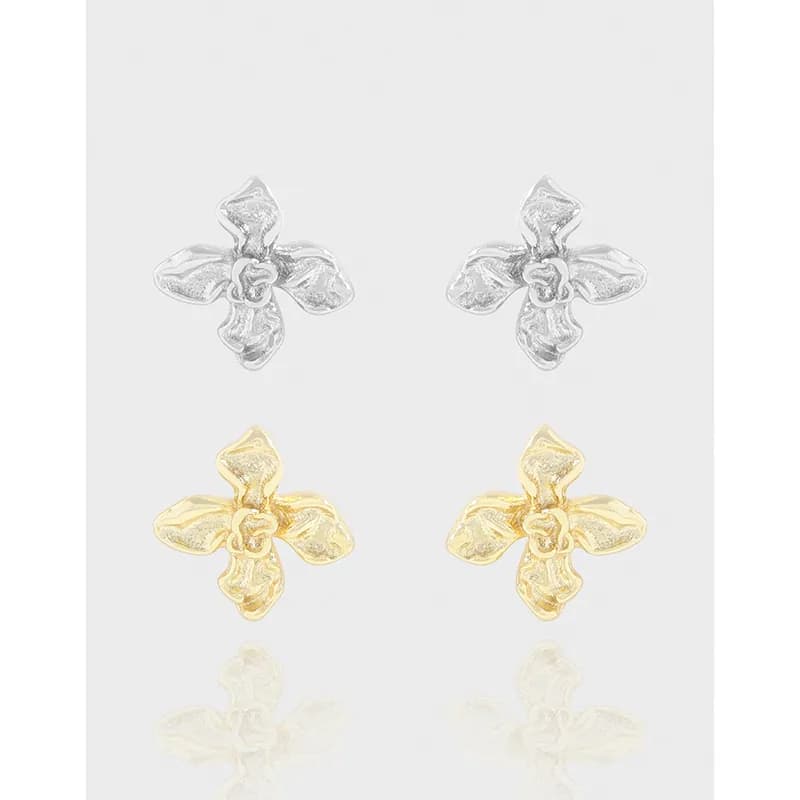 Double set of four-petaled flower stud earrings in silver and gold tones with textured petals.