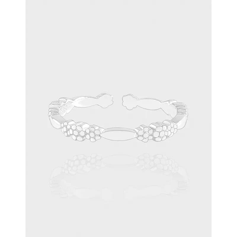 Polished sterling silver ring with small floral clusters linked along a slender curved band.