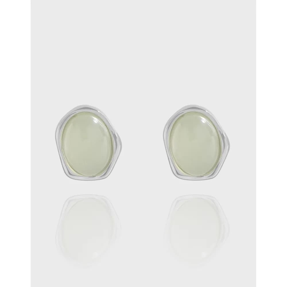 Two sterling silver stud earrings with oval pale green stones in bezel settings.