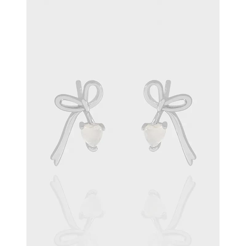 Polished sterling silver bow-shaped stud earrings with small pale bead drop.