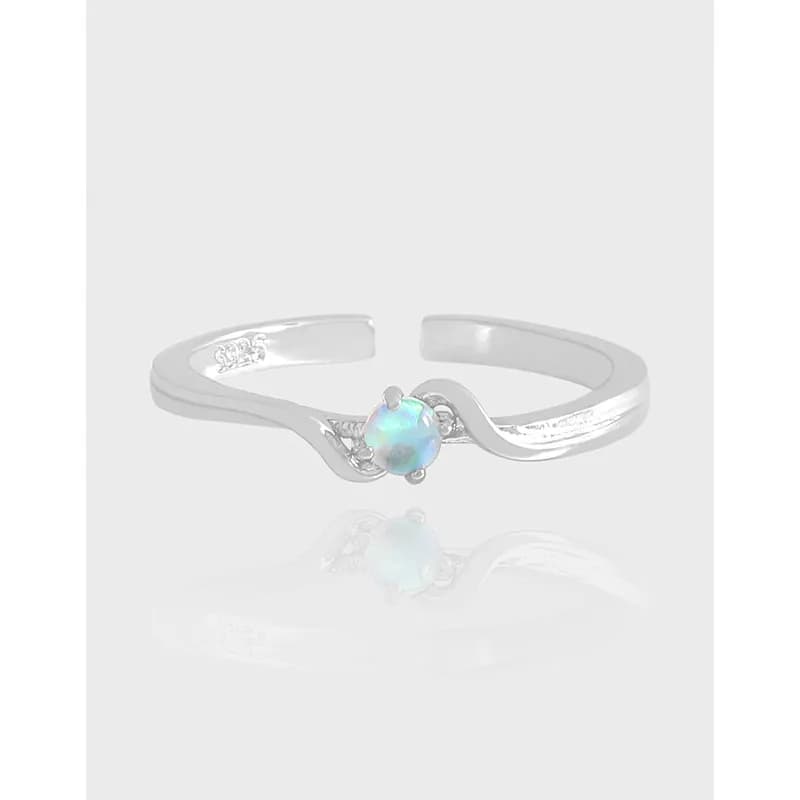 Polished silver ring with a central opal gemstone and curved band design.