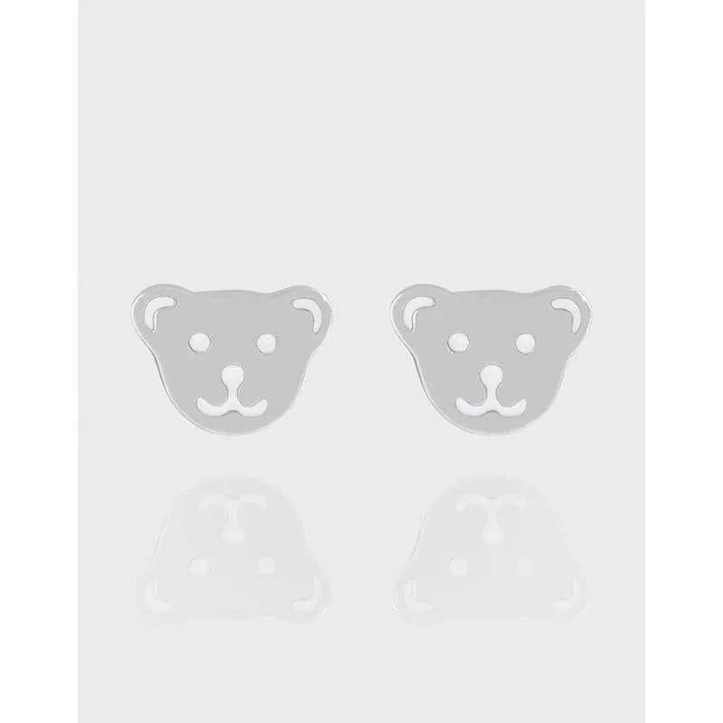Polished silver bear face stud earrings on a light background.