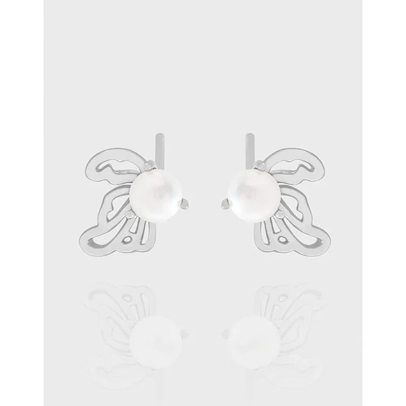 Polished sterling silver stud earrings with white pearls and butterfly-like wing accents.