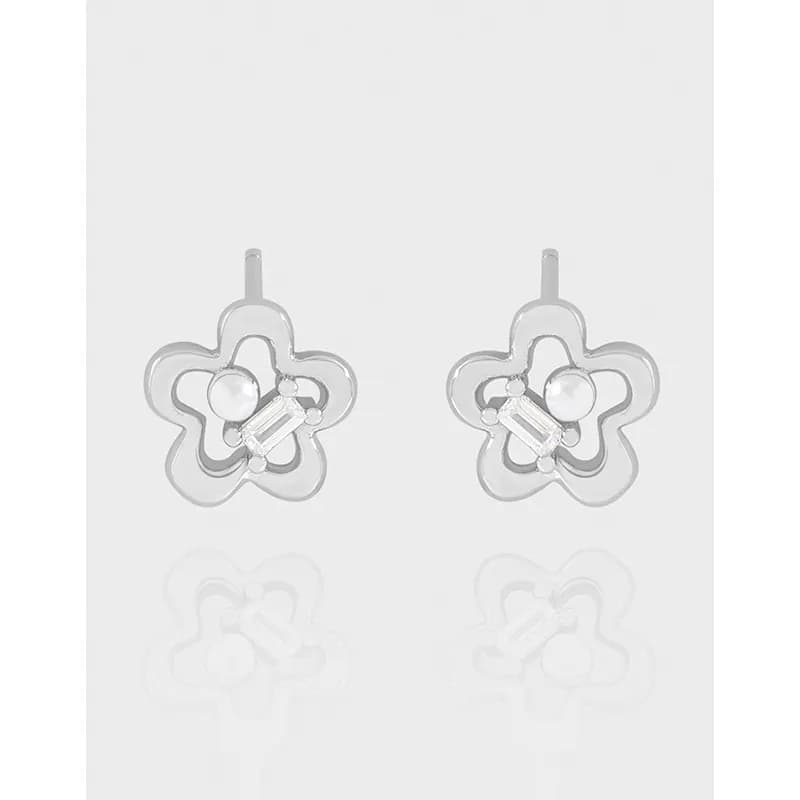 Polished sterling silver flower-petal earrings with central pearl and rectangular crystal on a white background.