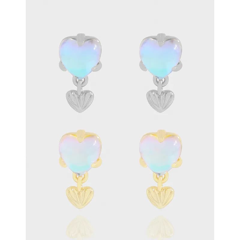 Iridescent heart drop earrings in a polished silver finish with a small dangling heart charm.