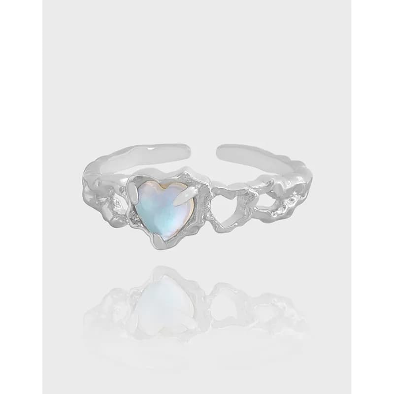 Close-up of a polished sterling silver ring with a heart-shaped opal centerpiece.