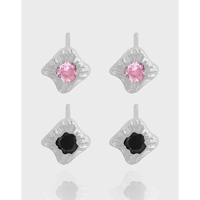 Pair of sterling silver floral-frame stud earrings with pink or black center stones and an enamel finish.