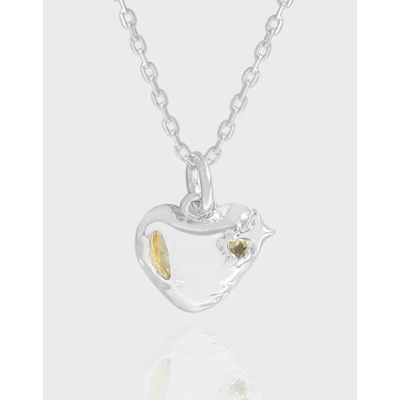 Polished sterling silver heart pendant on a delicate chain with gold-tone accents.