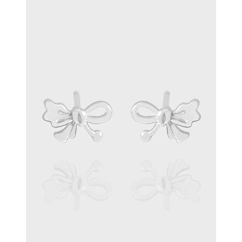 Pair of polished sterling silver bow-shaped stud earrings on a light background.