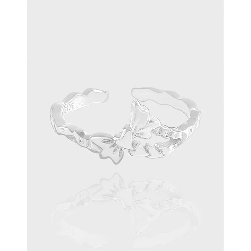 Polished sterling silver open-band ring with a butterfly-petal centerpiece on a light background.