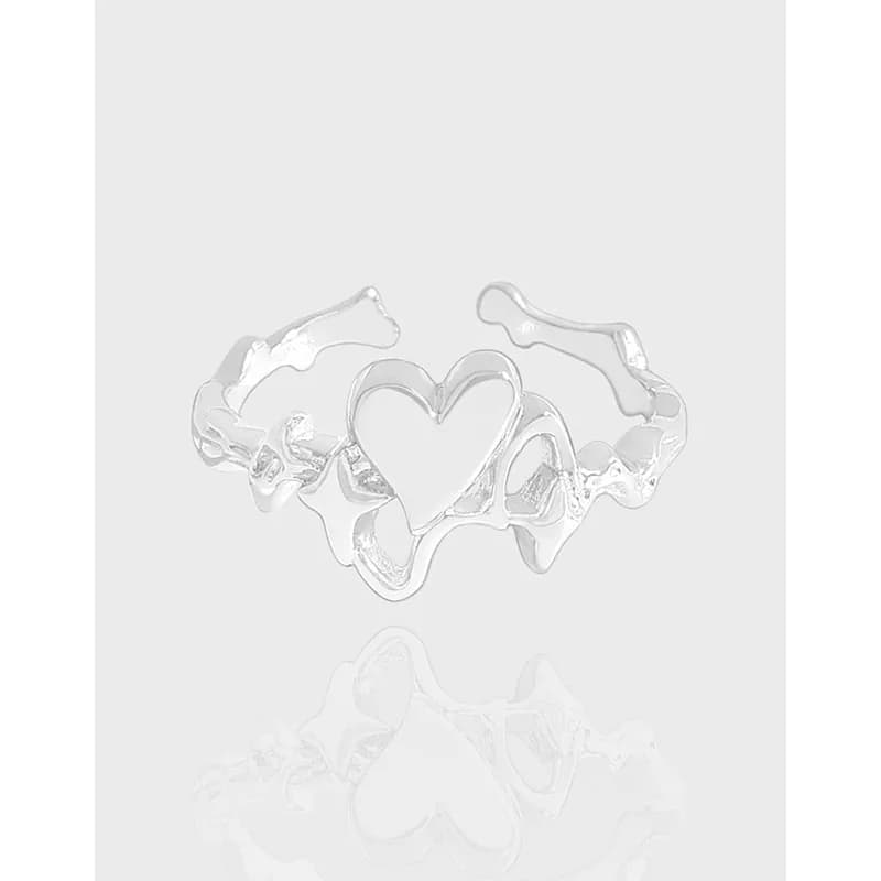 Polished sterling silver ring with a central open heart motif and organic, wavy band on a light background.