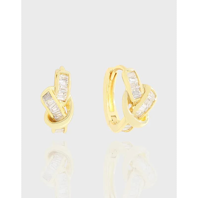 Polished sterling silver interlocking ribbon earrings with baguette stones on a light background.