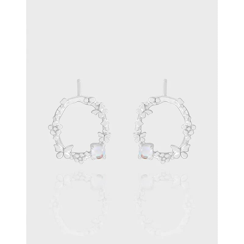 Polished sterling silver floral hoop earrings with a single opalescent gemstone at the bottom