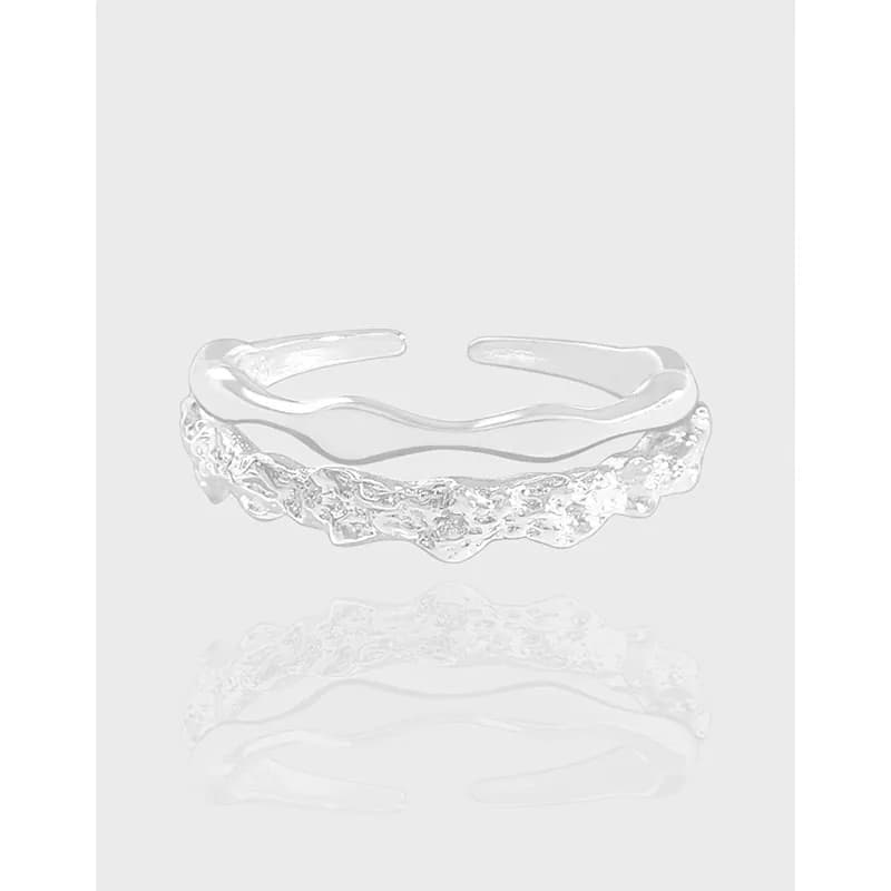 Open-ended sterling silver ring with a textured, cluster-like front on a light gray background.