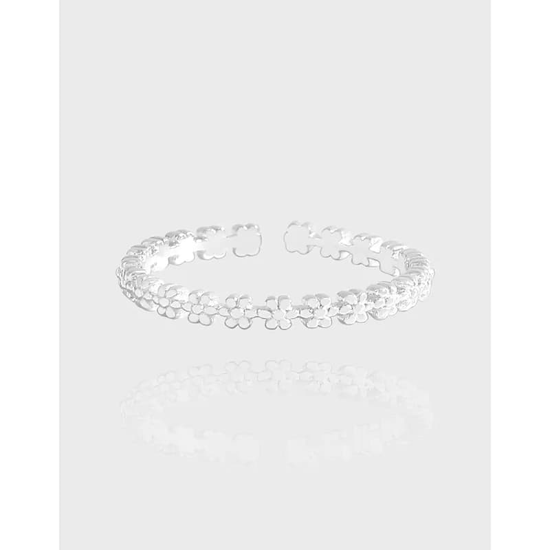 Polished sterling silver ring with a continuous row of flower-shaped links forming a delicate band.